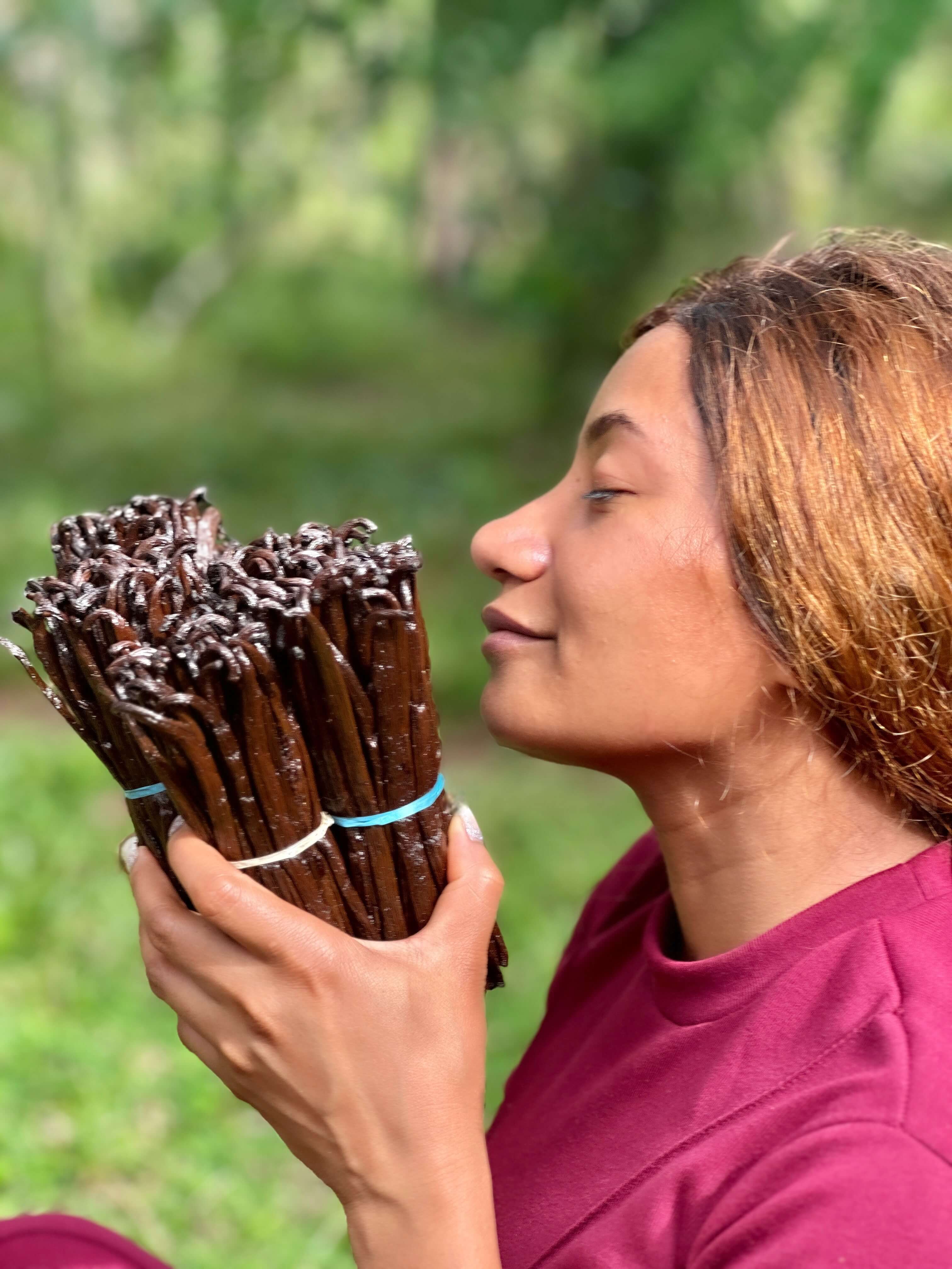 Unternehmerin riecht begeistert an frisch fermentierter Bourbon-Vanille – authentischer Moment aus der Herkunftsregion Maroantsetra